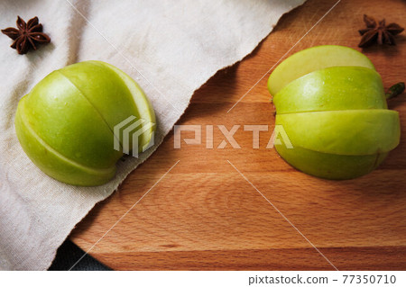 sliced green apple on wooden cutting board 77350710