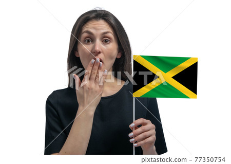 Happy young white woman holding flag of Jamaica and covers her mouth with her hand isolated on a white background Happy young white woman holding flag of Jamaica and covers her mouth with her hand isolated on a white background 77350754
