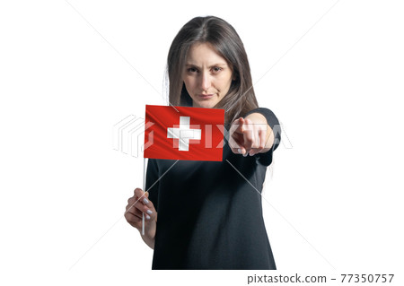 Happy young white woman holding flag of Switzerland and points forward in front of him isolated on a white background 77350757