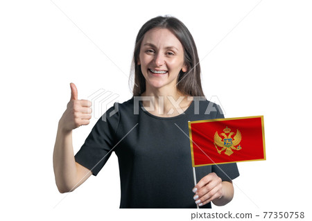Happy young white woman holding flag of Montenegro and shows the class by hand isolated on a white background 77350758