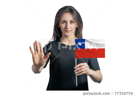 Happy young white woman holding flag of Chile and with a serious face shows a hand stop sign isolated on a white background 77350759