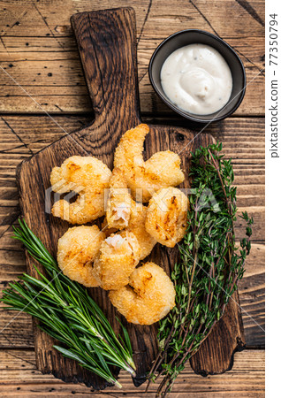 Fried Crispy Shrimps Prawns on a wooden board with sauce. wooden background. Top view Fried Crispy Shrimps Prawns on a wooden board with sauce. wooden background. Top view 77350794
