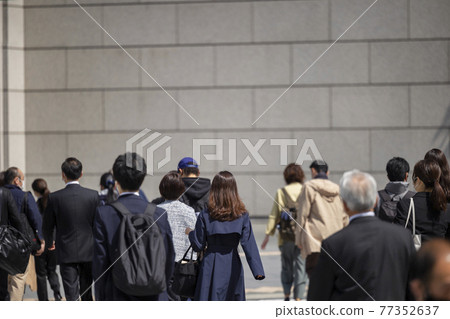 Back view of a walking woman commuting in the morning 77352637