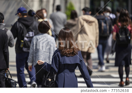 Back view of a walking woman commuting in the morning 77352638