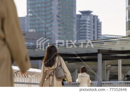 Back view of a walking woman commuting in the morning 77352646