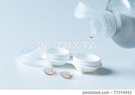 Contact lenses, case and bottle with solution on white background. selective focus 77354042