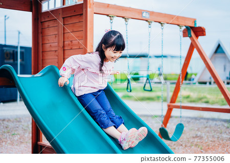 Little girl playing on the slide Little girl playing on the slide 77355006