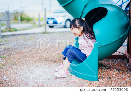 Little girl playing on the slide Little girl playing on the slide 77355008