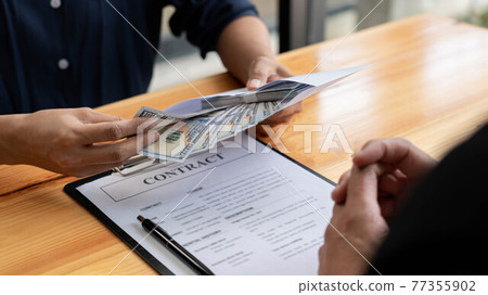Businessman reciving money United States Dollars bills to corruption from his partner in business at working desk - bribery concept. 77355902