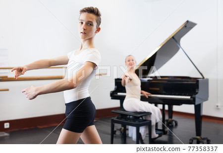 Female choreographer teaches young dancer in ballet studio 77358337
