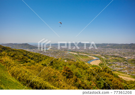 藍天下飛翔的滑翔傘。在城之川市寺山天空體育 藍天下飛翔的滑翔傘。在城之川市寺山天空體育 77361208