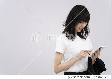 A woman using a mobile phone 77362373