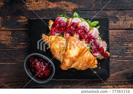 Sandwich with Duck breast fillet steak slices, arugula and sauce. Dark wooden background. Top View Sandwich with Duck breast fillet steak slices, arugula and sauce. Dark wooden background. Top View 77363158