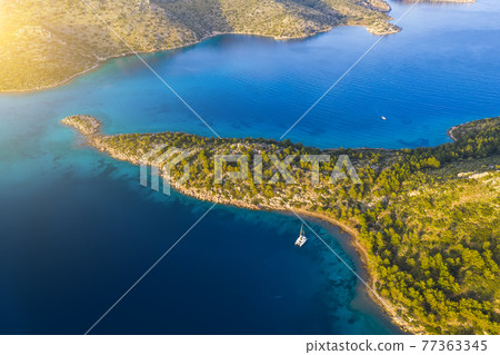 Aerial view of a catamaran yacht in the blue sea. Yachting, luxury vacation at sea. Aerial view of a catamaran yacht in the blue sea. Yachting, luxury vacation at sea. 77363345