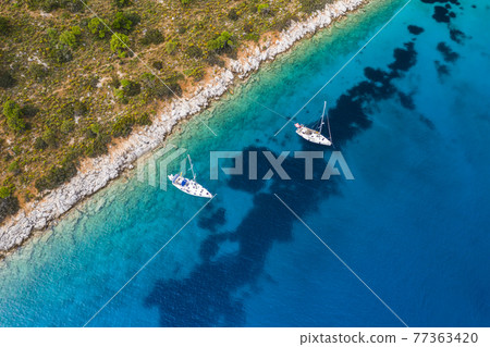 Yacht sailing near the rocky coast in Turkey. Luxury vacation at sea Yacht sailing near the rocky coast in Turkey. Luxury vacation at sea 77363420