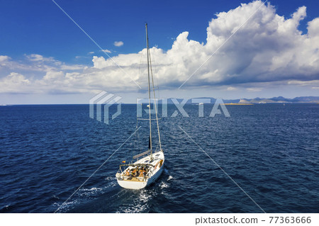 Yacht sailing at sunset during a storm. Luxury vacation at sea 77363666