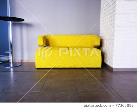 Small yellow couch near white wall in interior Small yellow couch near white wall in interior 77363892