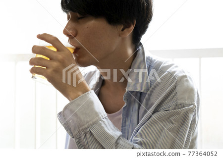 男人在房間裡喝啤酒 77364052