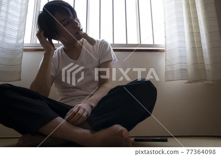 Man eating ice cream in the room 77364098