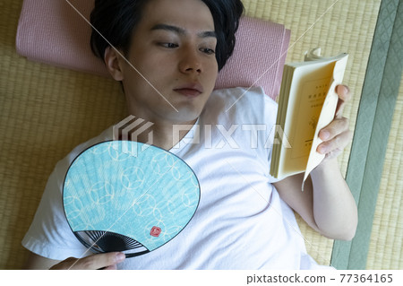A man reading in a room A man reading in a room 77364165