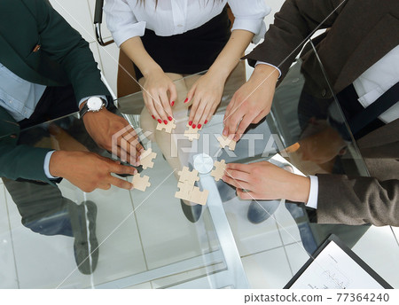 view from the top.business team folding puzzle pieces. 77364240
