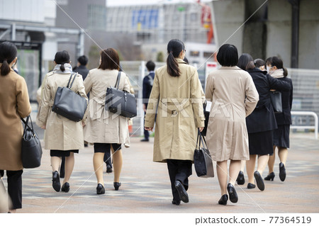 Back view of a female student who is looking for a job 77364519