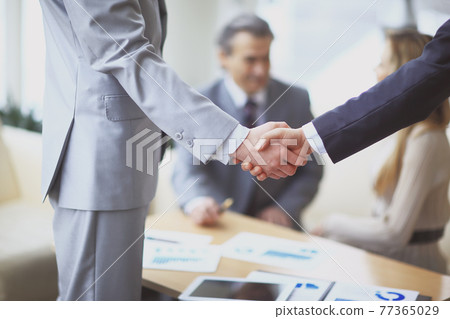 close up.handshake of business partners on the background of the workplace close up.handshake of business partners on the background of the workplace 77365029