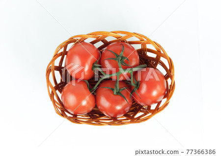 branch of ripe tomatoes in a wicker basket.isolated on white branch of ripe tomatoes in a wicker basket.isolated on white 77366386