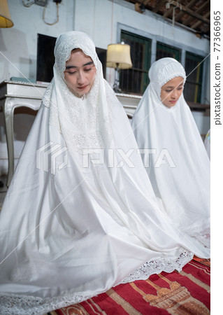 muslim family praying jamaah together at home 77366965