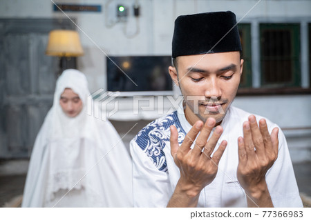 muslim husband and wife praying jamaah together at home 77366983