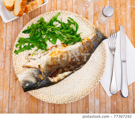 Fresh baked fish sea bass with arugula Fresh baked fish sea bass with arugula 77367292