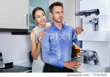 Family couple looking for modern functional mixer tap 77367605