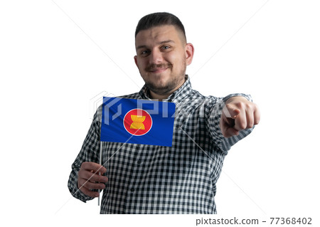 White guy holding a flag of Association of Southeast Asian Nations and points forward in front of him isolated on a white background White guy holding a flag of Association of Southeast Asian Nations and points forward in front of him isolated on a white background 77368402
