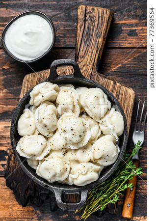 Russian Dumplings Pelmeni with beef and pork meat. Dark wooden background. top view 77369564