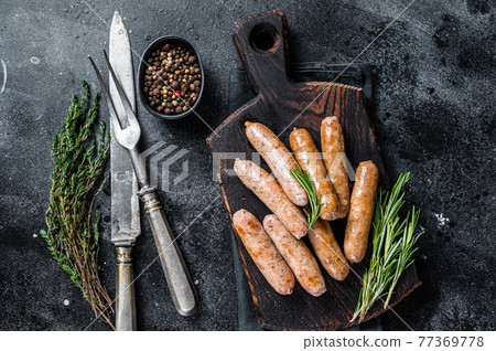 Fried Bratwurst or Hot Dogs sausages on a wooden board. Black background. Top View Fried Bratwurst or Hot Dogs sausages on a wooden board. Black background. Top View 77369778