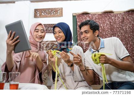 muslim family and friend making ketupat for eid fitr mubarak 77371198