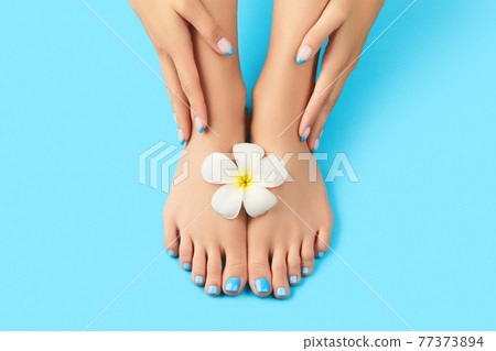 Manicure, pedicure beauty salon concept. Womans feet on blue background 77373894