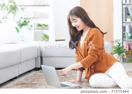 Young woman laptop living room 77375464
