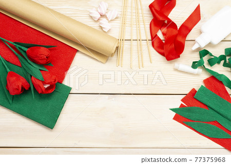 How to make a tulip flower out of paper and marshmallows at home. Marshmallow inside a red tulip bud. Hands make a red tulip. Step-by-step instruction. DIY children's art project 77375968