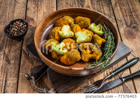 Breadcrumb broccoli in a wooden plate with thyme. wooden background. Top view Breadcrumb broccoli in a wooden plate with thyme. wooden background. Top view 77376403