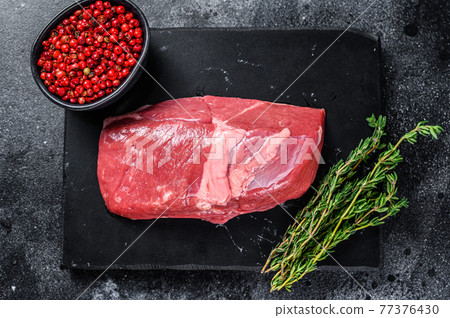 Raw lamb meat leg steak on a stone board. Black background. Top view Raw lamb meat leg steak on a stone board. Black background. Top view 77376430