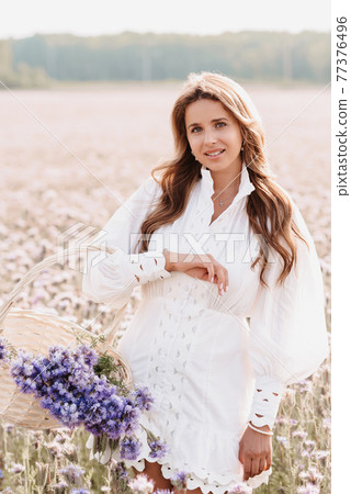 girl in the field with a bouquet of flowers in a basket in nature girl in the field with a bouquet of flowers in a basket in nature 77376496