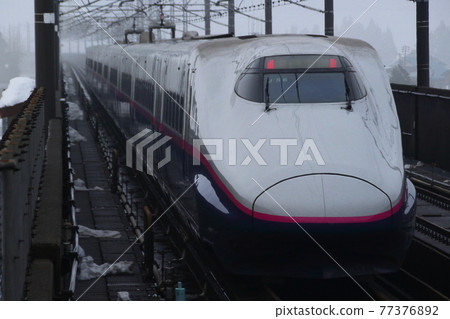 Joetsu Shinkansen E2 series 1000 series going through Niigata prefecture in winter 77376892