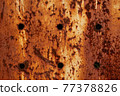 Texture of a rusty metal surface with holes, closeup 77378826