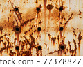 Texture of a rusty metal surface with holes, closeup 77378827
