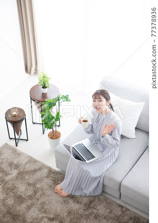 年輕女子客廳筆記本電腦 77378936