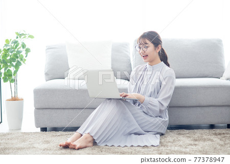 年輕女子客廳筆記本電腦 77378947