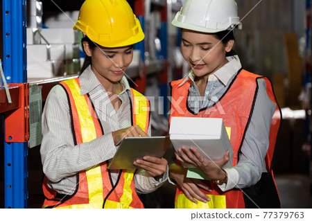 Female warehouse worker working at the storehouse 77379763