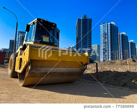 Large powerful modern yellow roller for asphalt paving, repair and road construction. New construction machinery and equipment at the construction site 77380899