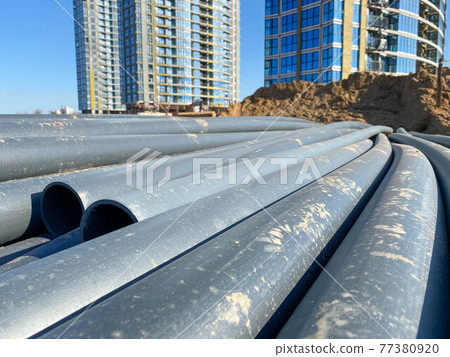 Large industrial black plastic polypropylene modern large diameter plumbing plumbing pipes at construction site in water pipe laying and construction and renovation of buildings and houses 77380920